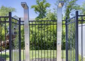 Thumbnail 12 of 37 - a wrought iron gate with two pillars in front of a garden at Aventura at Towne Centre, Ellisville