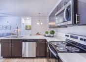 Thumbnail 20 of 37 - a kitchen with stainless steel appliances and a stove and a microwave at Aventura at Towne Centre, Ellisville, MO