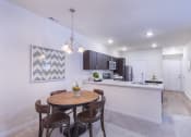 Thumbnail 29 of 37 - a dining room with a table and chairs next to a kitchen at Aventura at Towne Centre, Ellisville, Missouri