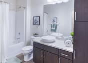 Thumbnail 30 of 37 - a bathroom with a toilet sink and shower and a mirror at Aventura at Towne Centre, Missouri