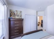 Thumbnail 34 of 37 - a bedroom with a bed and a dresser and a closet at Aventura at Towne Centre, Ellisville, 63011