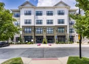 Thumbnail 1 of 29 - a large apartment building with a sidewalk in front of it at Aventura at Wild Horse Creek, Chesterfield, Missouri