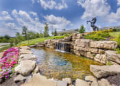 Thumbnail 3 of 29 - a pond with a waterfall and a statue on a hill at Aventura at Wild Horse Creek, Chesterfield
