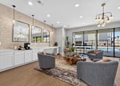 Thumbnail 8 of 16 - A modern living room with a grey sofa, a wooden coffee table, and a large window overlooking the city.