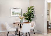 Thumbnail 1 of 16 - A dining room with a table, chairs, and a painting on the wall.