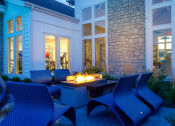 Thumbnail 35 of 37 - an outdoor patio with blue chairs and a fire pit at The Edison at Blue Springs, Missouri, 64014