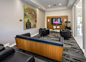 Thumbnail 6 of 30 - A modern living room with a couch, chair, and television.