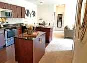 Thumbnail 7 of 31 - a kitchen with a center island and a living room  at Aventura at Richmond, St. Peters