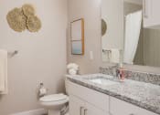 Thumbnail 11 of 37 - a bathroom with a toilet sink and mirror at The Edison at Blue Springs, Blue Springs, MO 64014
