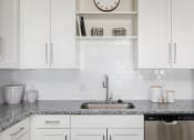 Thumbnail 5 of 37 - a kitchen with white cabinets and granite countertops at The Edison at Blue Springs, Blue Springs, MO 64014