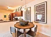Thumbnail 4 of 22 - a dining area with a table and chairs and a kitchen in the background  at Aventura at Mid Rivers, St. Charles, Missouri