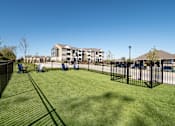 Thumbnail 15 of 16 - A grassy area in front of a building with a black fence.