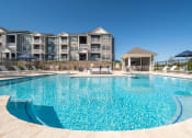 Thumbnail 2 of 28 - a swimming pool with an apartment building in the background  at Aventura at Hawk Ridge, Lake St Louis