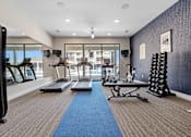 Thumbnail 29 of 41 - A gym with a row of treadmills and other exercise equipment at Aventura at Wentzville I & II Apartments, Wentzville, MO, 63385