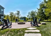 Thumbnail 26 of 31 - a patio with chairs and a fire pit in a park at Aventura at Richmond, St. Peters, Missouri