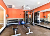 Thumbnail 23 of 31 - a gym with a lot of exercise equipment and a ceiling fan at Aventura at Richmond, St. Peters, 63376