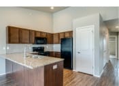 Thumbnail 22 of 41 - Kitchen with Granite Countertops, Black Appliances and Breakfast Bar