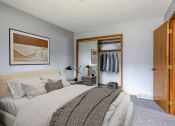 Thumbnail 10 of 25 - a bedroom with a large bed and a closet with clothes in it