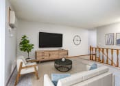 Thumbnail 2 of 25 - a living room with white walls and a large tv on the wall