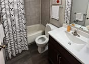 Thumbnail 7 of 18 - A bathroom with a toilet, sink, and shower.