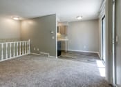 Thumbnail 15 of 25 - a living room with a staircase and a kitchen in the background