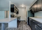 Thumbnail 3 of 22 - a kitchen with brown cabinets and white countertops