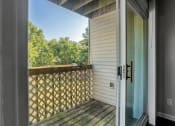 Thumbnail 9 of 22 - a door opens to a balcony with a view of trees and a blue sky