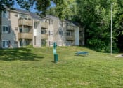 Thumbnail 18 of 22 - a grassy area with a picnic table in front of an apartment building