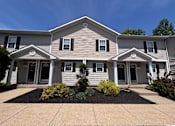 Thumbnail 20 of 21 - A house with a grey siding and white trim.