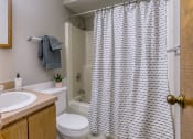 Thumbnail 20 of 25 - a bathroom with a white sink and toilet and a white shower curtain