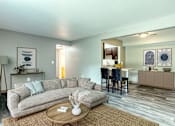 Thumbnail 1 of 18 - A living room with a grey couch and a coffee table.