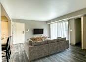 Thumbnail 3 of 18 - A grey couch with a wooden table in front of it.