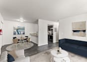 Thumbnail 1 of 22 - A living room with a white couch and a glass table.