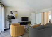 Thumbnail 1 of 22 - a living room with a couch and chair and a television
