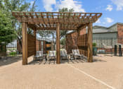 Thumbnail 16 of 50 - a wooden pergola with lounge chairs on a gravel patio at The Hills at Ironhorse, Texas