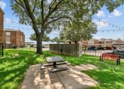 Thumbnail 36 of 50 - a picnic area with a table and benches in the middle of a grassy area at The Hills at Ironhorse, North Richland Hills, TX, 76180