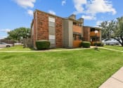 Thumbnail 31 of 50 - an apartment building with a green lawn and trees in the background at The Hills at Ironhorse, North Richland Hills, 76180