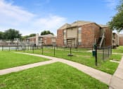 Thumbnail 25 of 47 - a fenced in area with a tennis court in front of a building at The Hudson, Texas, 76180