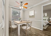 Thumbnail 21 of 56 - a dining room with a table and chairs and a ceiling fan at 5636 Apartment Homes, Texas, 75254