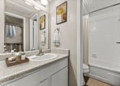 Thumbnail 25 of 56 - a bathroom with a sink and a shower and a mirror at 5636 Apartment Homes, Dallas, TX
