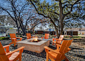 Thumbnail 10 of 15 - a group of orange chairs around a fire pit at Peaks at Northwest Hills Apartments, Texas, 78731