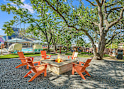 Thumbnail 9 of 15 - a patio with a fire pit and chairs around it at Peaks at Northwest Hills Apartments, Austin, Texas