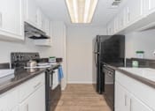 Thumbnail 41 of 68 - a kitchen with white cabinets and a black refrigerator at The Escapade, San Antonio, Texas