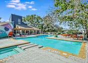 Thumbnail 4 of 15 - a swimming pool with a house in the background at Peaks at Northwest Hills Apartments, Austin, TX