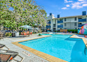 Thumbnail 6 of 15 - a swimming pool with an apartment building in the background at Peaks at Northwest Hills Apartments, Austin