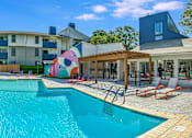 Thumbnail 5 of 15 - our apartments have a large swimming pool with chairs and umbrellas at Peaks at Northwest Hills Apartments, Austin, TX 78731