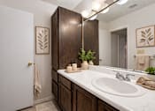 Thumbnail 11 of 43 - A bathroom with a white sink and a white door.