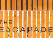 Thumbnail 19 of 68 - a sign for the escape room is painted on a wooden gate at The Escapade, San Antonio, 78216