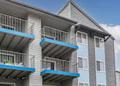 Thumbnail 34 of 63 - a gray apartment building with blue balconies at The Keller, San Antonio Texas  