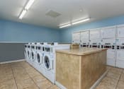 Thumbnail 31 of 63 - a laundry room with washers and dryers and a counter at The Keller, San Antonio, 78230  